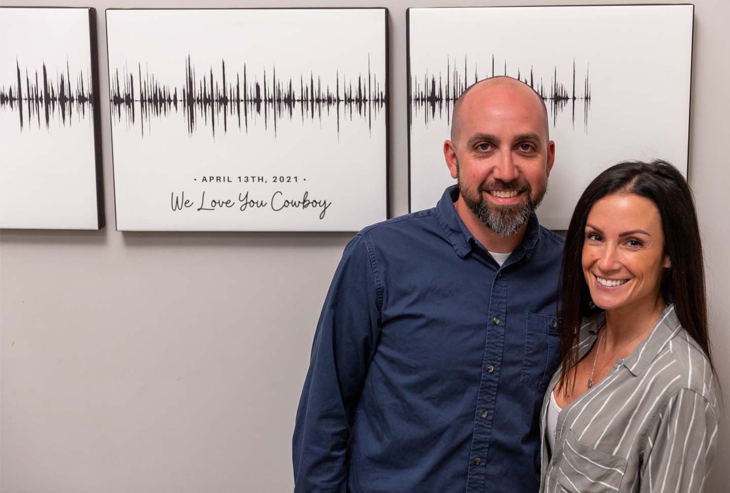 Scott and his girlfriend standing in front of the canvas art piece featuring the call from Dr. Davies.